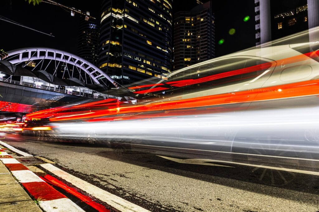 Night time long exposure low point of view from the curb side of a road with passing traffic