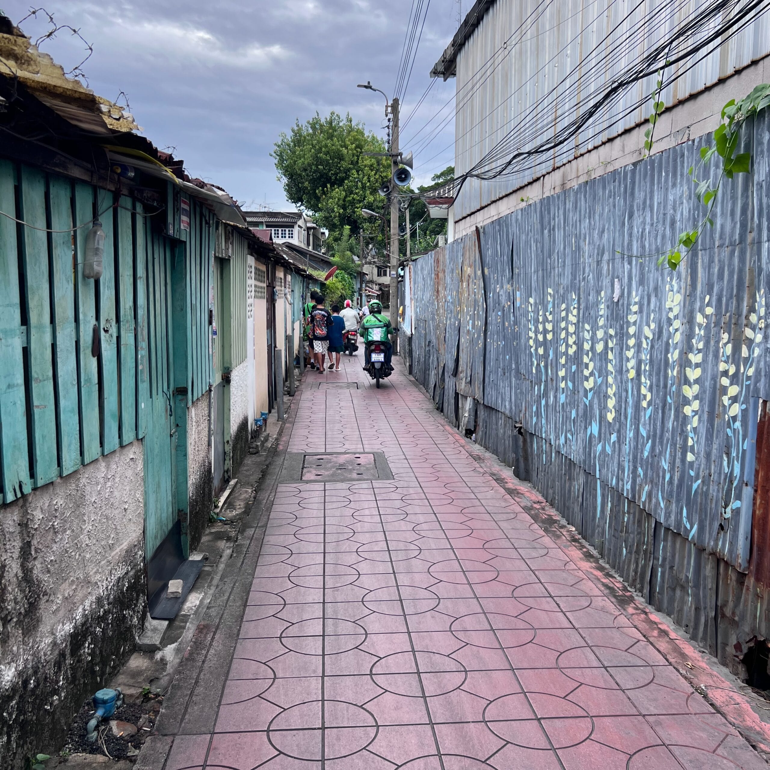 Narrow alley in Bangkok with murals on the walls