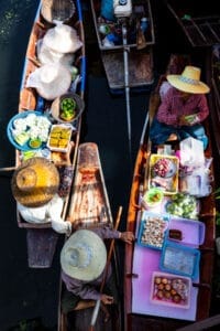 Women seen from above selling food from canoes at Tha Kha Floating Market, Bangkok.