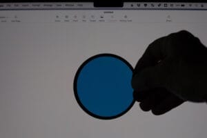 A polarising filter being held in front of a laptop screen