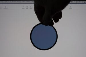 A polarising filter being held in front of a laptop screen