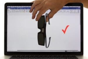 3-D polarising glasses held in front of a computer screen showing no light passing