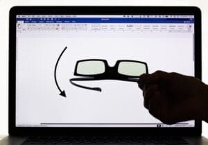 3-D polarising glasses held in front of a computer screen showing light passing
