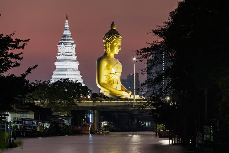 On the Talat Phlu food market walk The great Buddha of Paknam can be seen viewed from a canal at a distance. This shot was taken in the late evening after the Sun had set